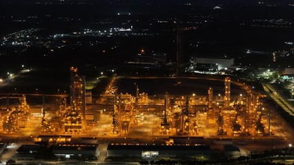 High angle view of industrial plant with pipes and tanks for mixing chemicals and gases at night.