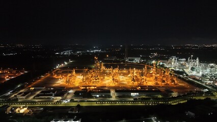 Fototapeta premium High angle view of industrial plant with pipes and tanks for mixing chemicals and gases at night.
