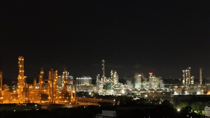 Fototapeta premium High angle view of industrial plant with pipes and tanks for mixing chemicals and gases at night.