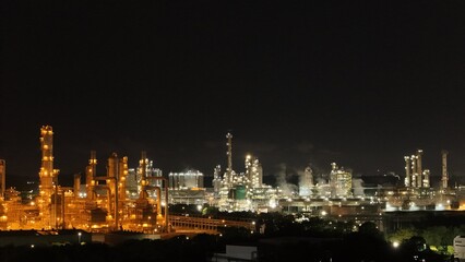 High angle view of industrial plant with pipes and tanks for mixing chemicals and gases at night.