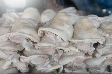 Boiled chicken hanging in a glass display at a food market, Front of the chicken rice restaurant.