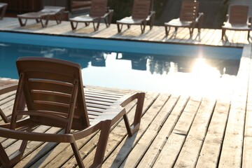 Outdoor swimming pool and sunbeds on sunny day