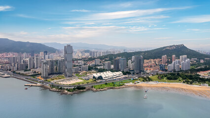Stunning Aerial View of a Coastal City with Blue Sky and Mountains