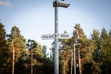 Road sign in Latvia indicates directions to Valga and Riga, showing the connection between these cities in Baltic region. Riga is a capital city of Latvia, Valga is a town at the border with Estonia.