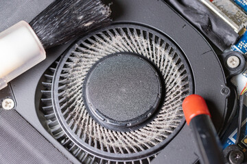 Top view of dirty and dusty computer cooling fan with cleaning brush and dust blower.