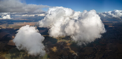 Aerial view from airplane window at high altitude of earth covered with puffy cumulus clouds...