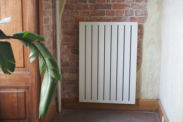 White radiator on grey white wall. apartment heating installation system, 