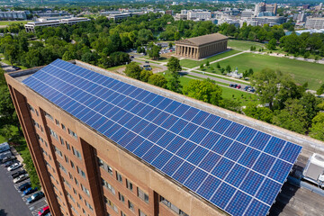 Apartment building with solar roof. Blue photovoltaic panels for producing clean ecological...