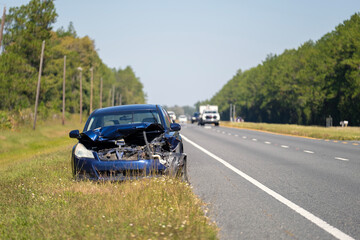 Crashed car damaged in traffic accident parked on road side. Abandoned broken vehicle