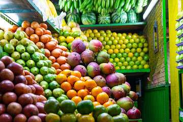 Display of stacked mandarins, guavas, mangos, lulos and pitayas at a farmer's market in the city of Medellin, Colombia.