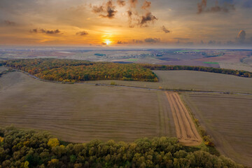 Plowed bare agricultural field with cultivated fertile soil prepared for seeding crops in autumn season