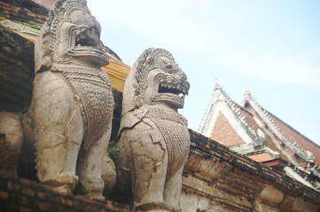 Beautiful and complete lion statue at the base of the main pagoda of Wat Mae Nang Pluem. which is another ancient temple in Phra Nakhon Si Ayutthaya Historical Park in Thailand.