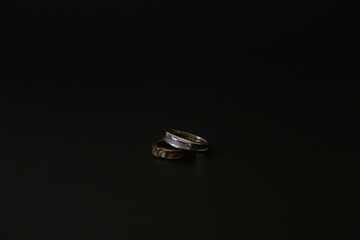 A stunning gold and silver wedding ring set against a black background, highlighting elegance and...