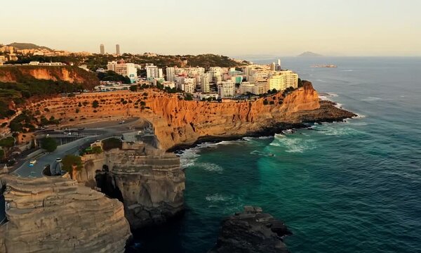 Drone captures a steady shot of the Cala Mosca area at Playa Flamenca, highlighting the beautiful contrast between the rugged landscape and the bustling urban backdrop along the Orihuela coast, Spain.