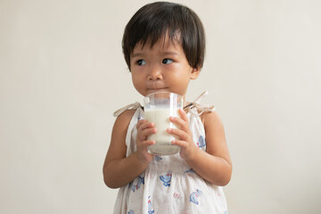 Child, cute girl drinking milk from a glass The concept of drinking milk for good health