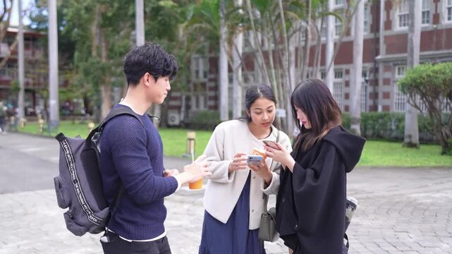 Young Taiwanese man and woman in their twenties chatting amiably with a South Asian woman in a slow-motion video on a university campus in Da&rsquo;an District, Taipei.