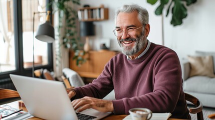 Obraz premium An elderly man smiling and holding glasses while sitting at an open laptop on the table of a home office