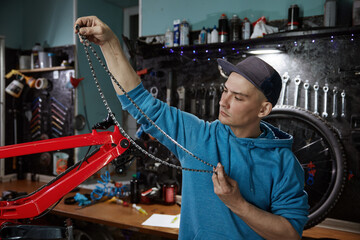 Professional male mechanic engaged in bicycle chain removal