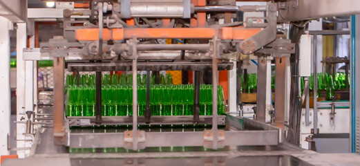 Glass factory, production of glass containers. Molten glass is blown into molds. Robotics in industry. Modern technologies, robotic machines produce products. Technological work at the plant.