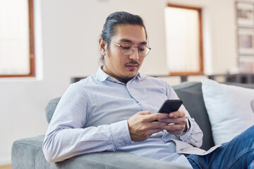 Businessman, online and relax with smartphone in office for research story, monitor news updates and check information. Male journalist, sofa and internet for communication with source and contact.