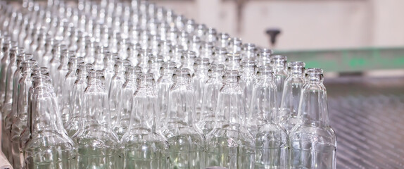 Glass factory, production of glass containers. Molten glass is blown into molds. Robotics in industry. Modern technologies, robotic machines produce products. Technological work at the plant.