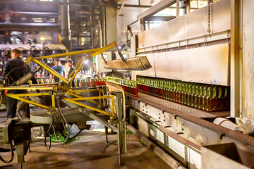 Glass factory, production of glass containers. Molten glass is blown into molds. Robotics in industry. Modern technologies, robotic machines produce products. Technological work at the plant.