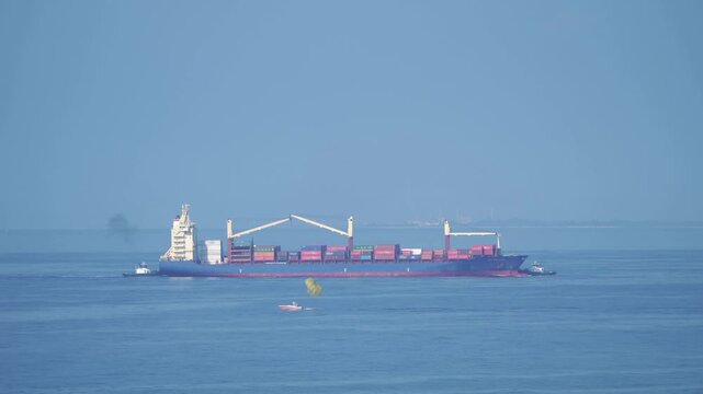 Container ship on the ocean viewed from a distane in 4k