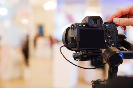 A professional camera on the blurred background of a banquet hall. 