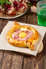 Traditional Georgian Adjarian Khachapuri with Bacon - Rustic Wooden Table Setting