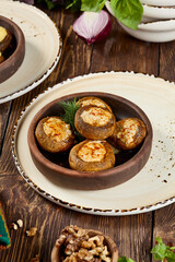 Baked Stuffed Mushrooms with Cheese and Bacon in Ketsi Dish on Wooden Table