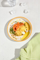 Gourmet Brioche with Poached Egg, Smoked Salmon, and Hollandaise Sauce on White Plate