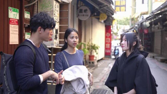 In an alley in Da'an District, Taipei, a slow-motion video shows a Taiwanese man and woman with a South Asian woman in their twenties, chatting amicably.
