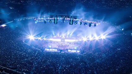 An expansive openair arena is transformed into a spectacular Kpop festival with fans lighting up the night with their flashlights.
