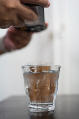 Man take a photo of cool water with ice at coffee shop