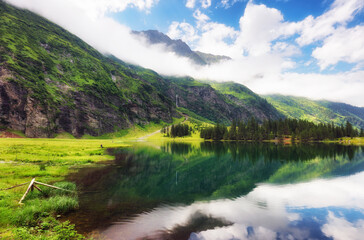 Fototapeta premium Beautiful summer lake landscape with mountain in the Autria Alps. Wonderful hiking spot. Alpine lake with high mountains. Pine trees. Hohe Tauern near Zell am See / Kaprun