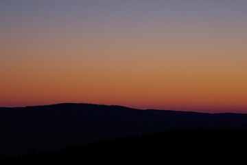 Vibrant lava apricot and mulberry hues blend in the evening sky