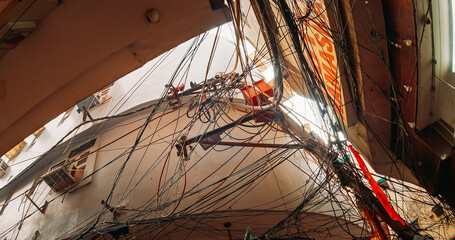 Electric cables chaos, Indian street wires. Messy electrical cables, Uncovered optical fiber technology open air outdoors in asian cities. utility pole supporting a mass of wiring, some of it © Great Brut Here