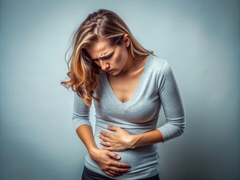 A distressed woman clutches her abdomen in discomfort, experiencing symptoms of reproductive health issues, gastrointestinal problems, or pregnancy-related complications.