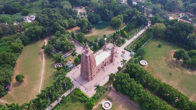 aerial view of a Sarnath temple Varanasi with tall spires, surrounded by greenery and gardens, with palm-lined pathways leading to it. India