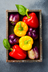Sweet colored bell peppers in a wooden box. Top view.