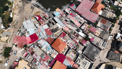 Aerial view of the slums in Luanda, Angola showcasing colorful rooftops and the river landscape beneath