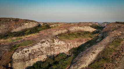 Aerial view of the Pedras Negras Mountains in Angola showcasing rugged terrain and lush vegetation under clear skies