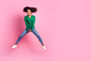 Full length photo of lovely young lady jump ride empty space dressed stylish green garment isolated on pink color background