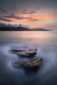 Sunset over the Cantabrian Sea at Lastron beach, Zierbana, Bizkaia with the waves between the rocks on the shore