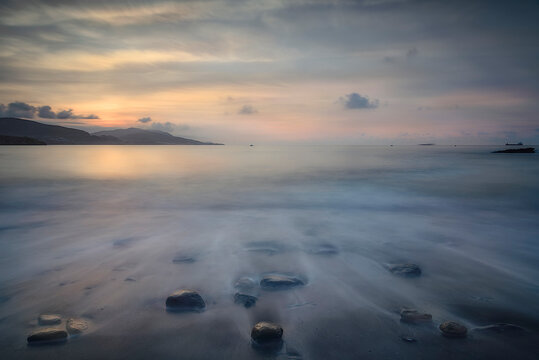 Sunset over the Cantabrian Sea at Lastron beach, Zierbana, Bizkaia with the waves between the rocks on the shore