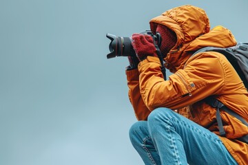 Fototapeta premium A Photographer in an Orange Jacket with a Backpack Takes a Picture