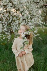 little girl in the spring  field with flowering tree