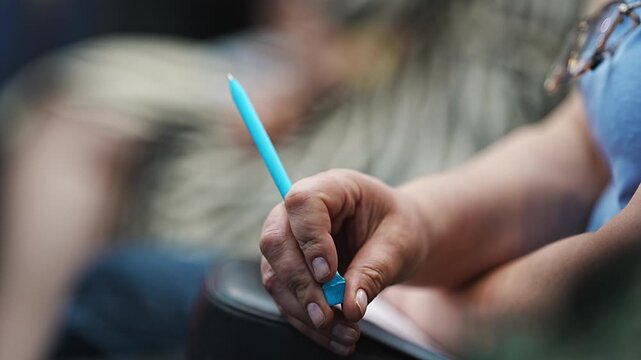 Hands, the woman is nervous and twists the pen