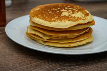 A big stack of breakfast pancakes on a kitchen table.