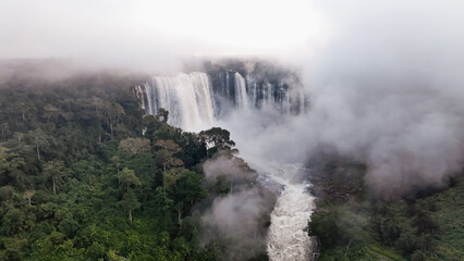 Kalandula Waterfall cascading through misty rainforest in Angola at midday